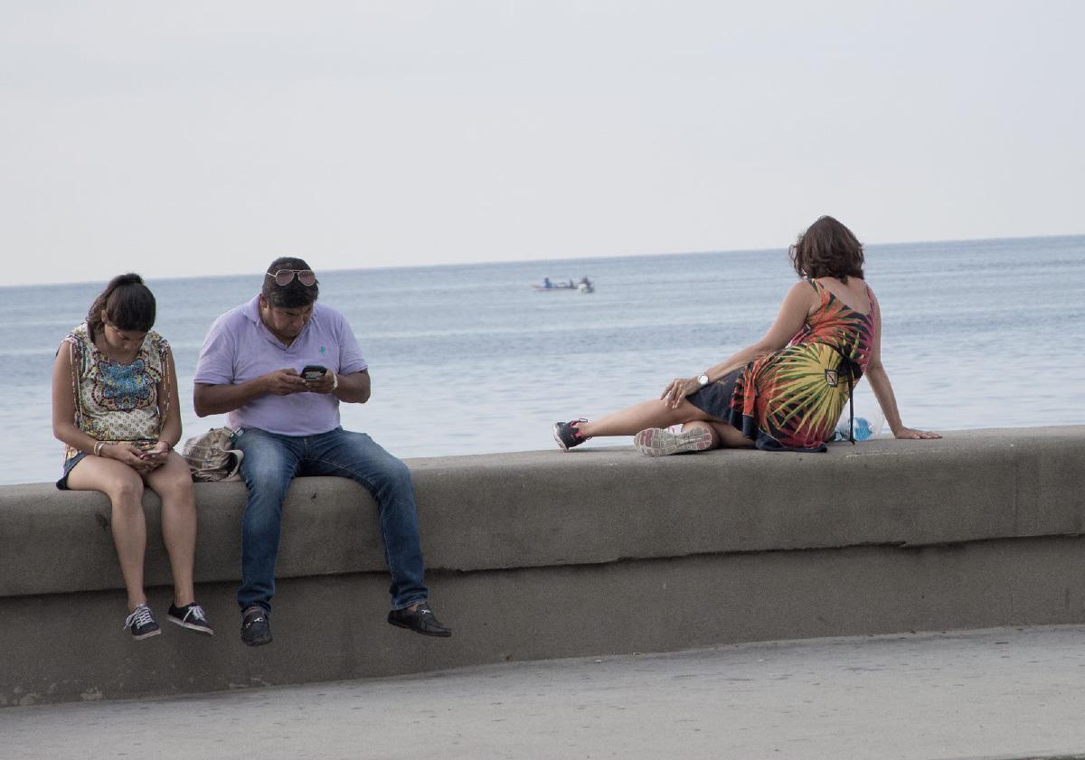Cubanos navegan a través de WiFi Nauta en uno de los sitios más emblemáticos de La Habana: el Malecón