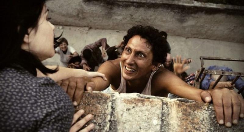 Juan trepa un muro entre la multitud en Juan de los Muertos
