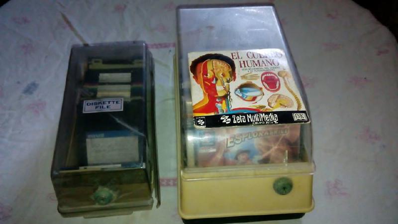 Un contenedor de disquettes 3 1/2 y uno de discos con enciclopedias.